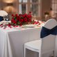 Velvet Ruffle Stretch Chair Band - Navy Blue on white chair | white tablecloth | gold trimmed dinner plate | wine goblets | flower centerpiece
