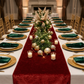 holiday dinner table with the Velvet Table Runner Apple Red, gold charger plates, emerald green velvet napkins and holiday greenery centerpieces
