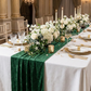 Velvet Table Runner Forest Green paired with white floral centerpieces, candles, and gold charger plates
