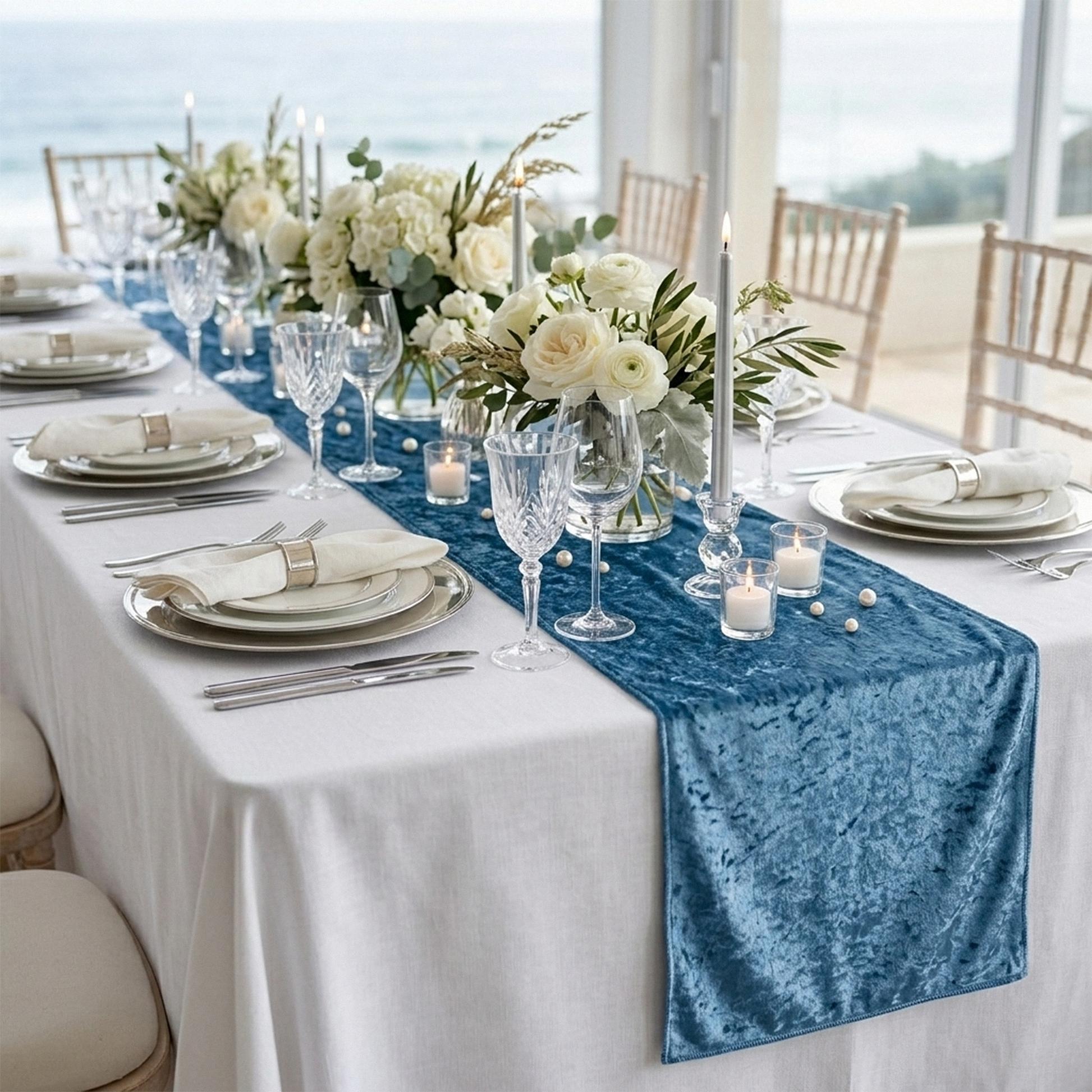 Velvet Table Runner Steele Blue on top a white polyester spun rectangular tablecloth, tapered candles, silver charger plates and dinner plates