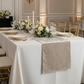 Velvet Table Runner Taupe on an ivory rectangular tabelcloth with white dinner plates, tapered candles and floral centerpieces

