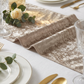 close up of the Velvet Table Runner Taupe on top a white premium spun polyester tablecloth with roses and greenery
