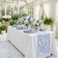 Vintage Lace Print Scuba Table Runner Dusty Blue/White on a rectangular table with dusty blue napkins and blue and white floral centerpieces