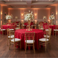 Wedding Rosette SATIN 132" Round Tablecloth - Apple Red with flower centerpieces | gold chiavari chairs