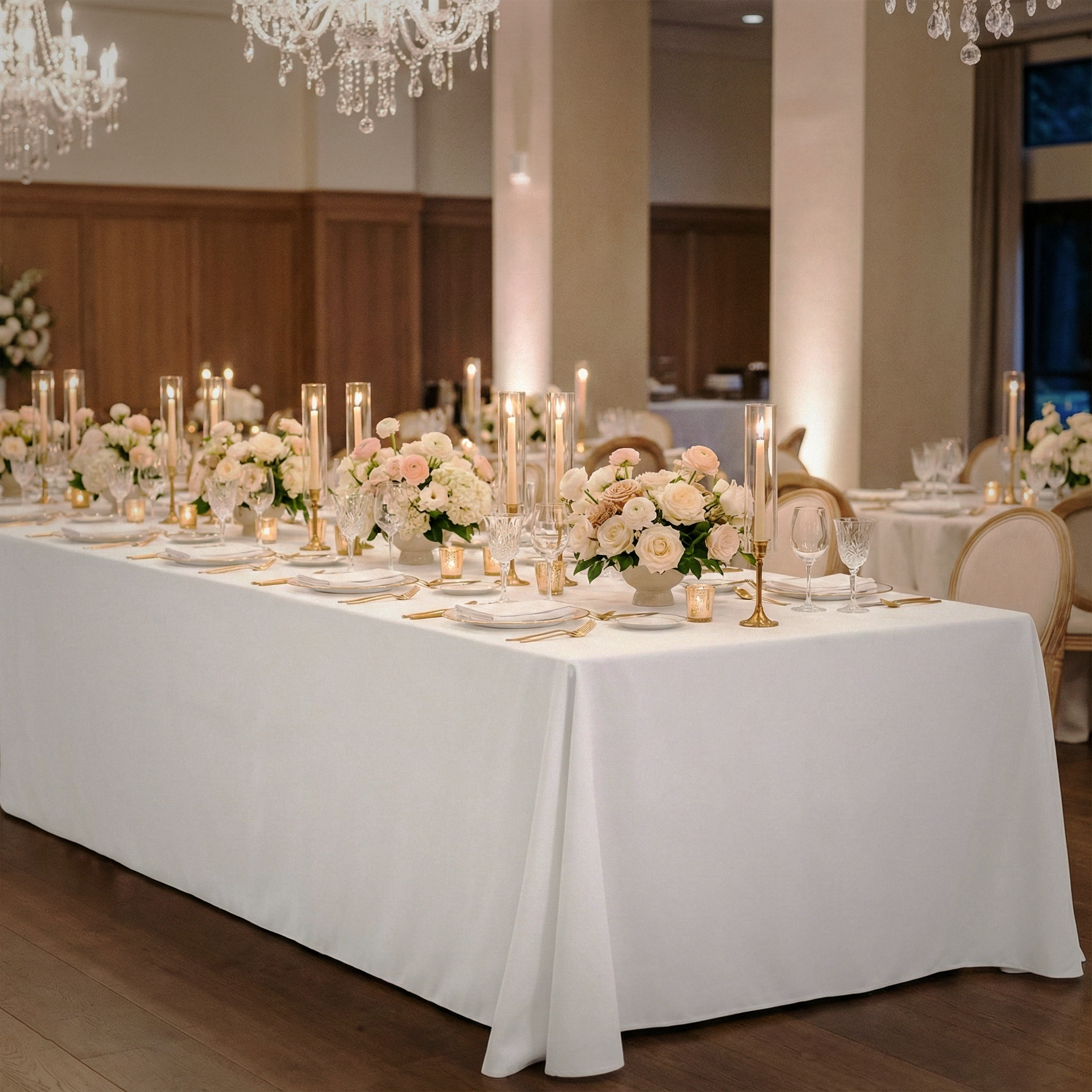Scuba King 108"x156" Rectangular Tablecloth White indoor wedding set up with floral centerpieces, gold charger plates, tapered candles, white dinnerware, and wine glasses