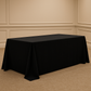 Black tablecloth on a rectangular table against a beige wall.