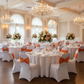 Indoor ballroom wedding with orange velvet ruffle chair bands