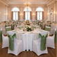 Indoor wedding reception with willow green satin chair sashes