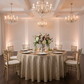 Glitz Sequins 132" Round Tablecloth - Champagne with Chiavari Gold Chairs.