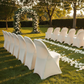 Folding Spandex Chair Cover - Ivory with Banquet Folding Chairs in Garden Reception.