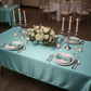 Close overhead top down view of teal satin tablecloth with place settings