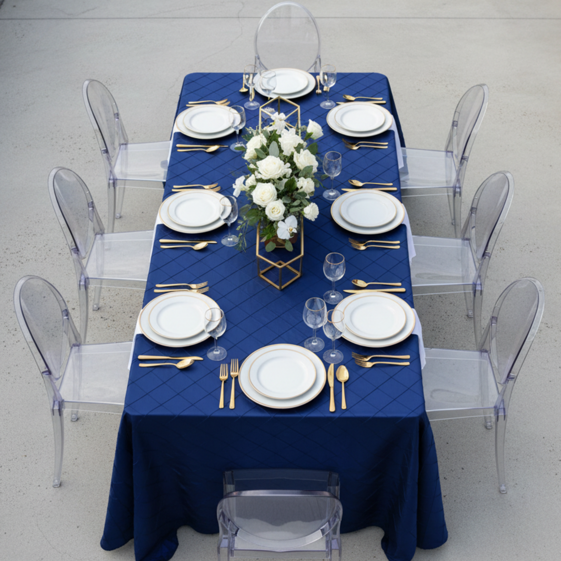 Aerial top-down view of navy blue pintuck tablecloth on 6ft table, rooftop setting