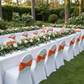 Outdoor garden wedding with orange velvet ruffle chair bands