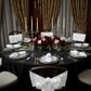Satin Napkin 20"x20" White on top of white dinner plates with red roses floral centerpiece