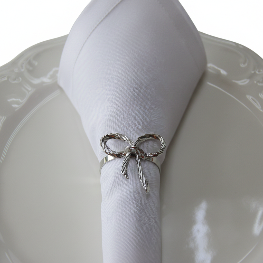 Silver rope bow tie napkin ring holding white linen napkin on white plate
