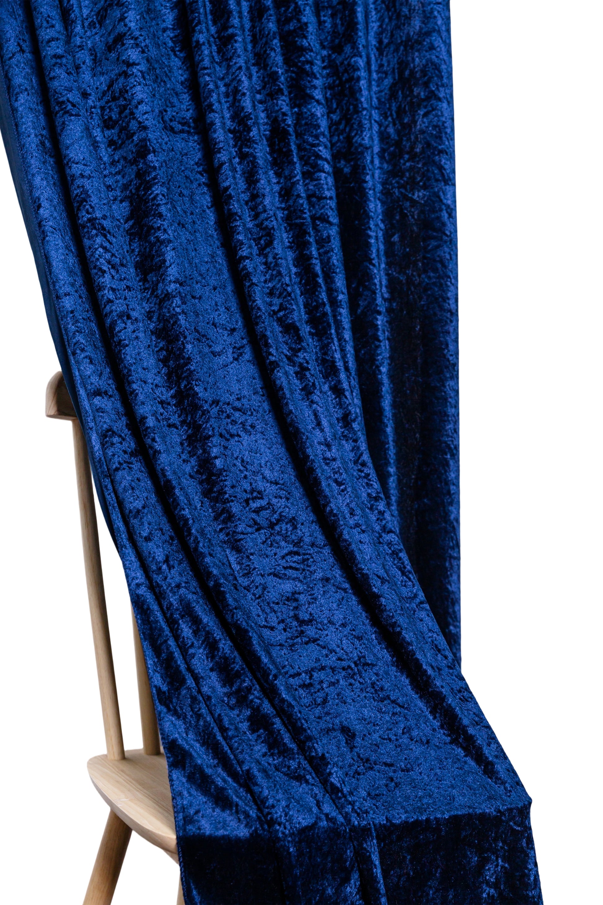 Navy blue velvet drape detail showing luxurious texture over wooden chair
