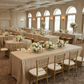 Indoor banquet hall event setup with champagne pintuck tablecloth
