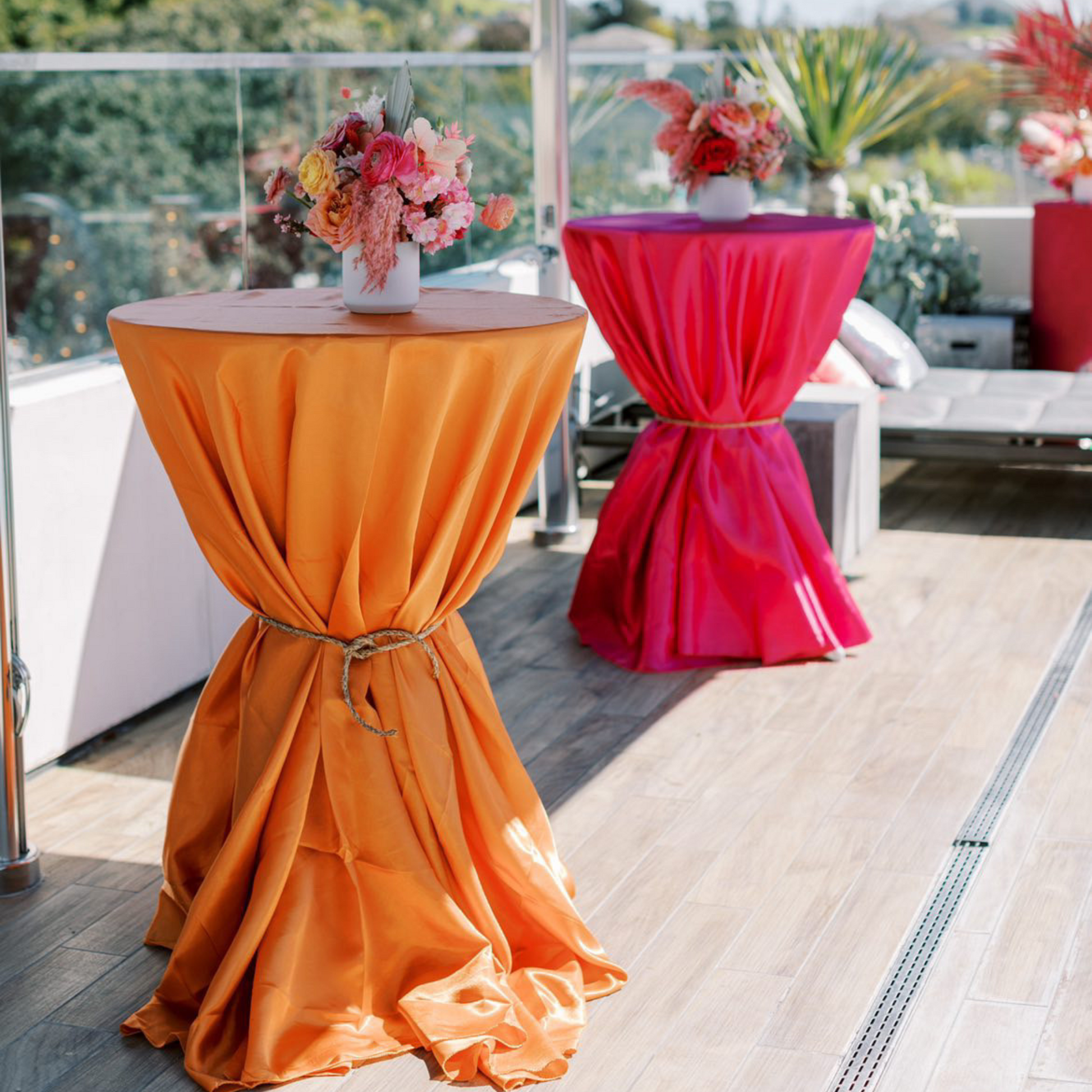 Satin 132" Round Tablecloth - Orange on top of 36" cocktail table hour glass look